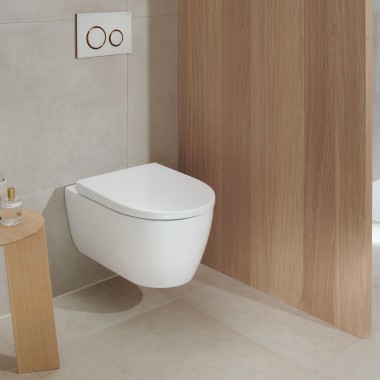 Un WC en céramique blanche dans une salle de bains avec des éléments en bois reste moderne même après de nombreuses années (ici : WC Geberit iCon et plaque de déclenchement Geberit Sigma20).