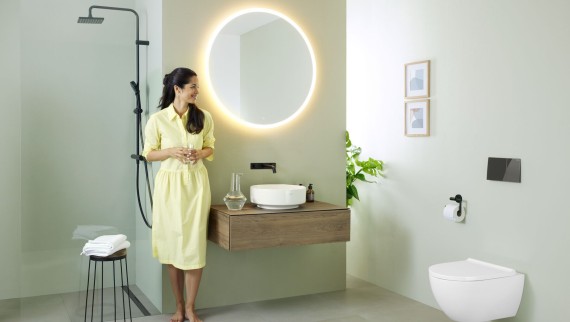 Femme dans une salle de bains comprenant un miroir Geberit Option et un lavabo Geberit VariForm