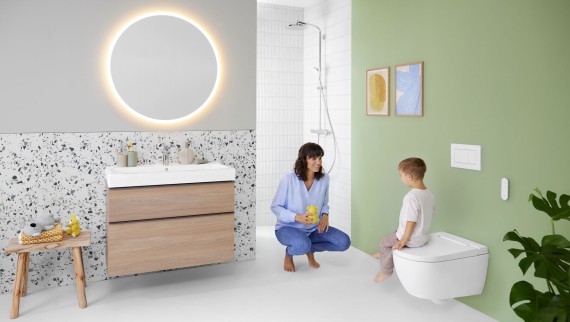 Une femme et un enfant dans une salle de bains avec un WC lavant Geberit AquaClean Alba Une femme et un enfant dans une salle de bains avec un WC lavant Geberit AquaClean Alba