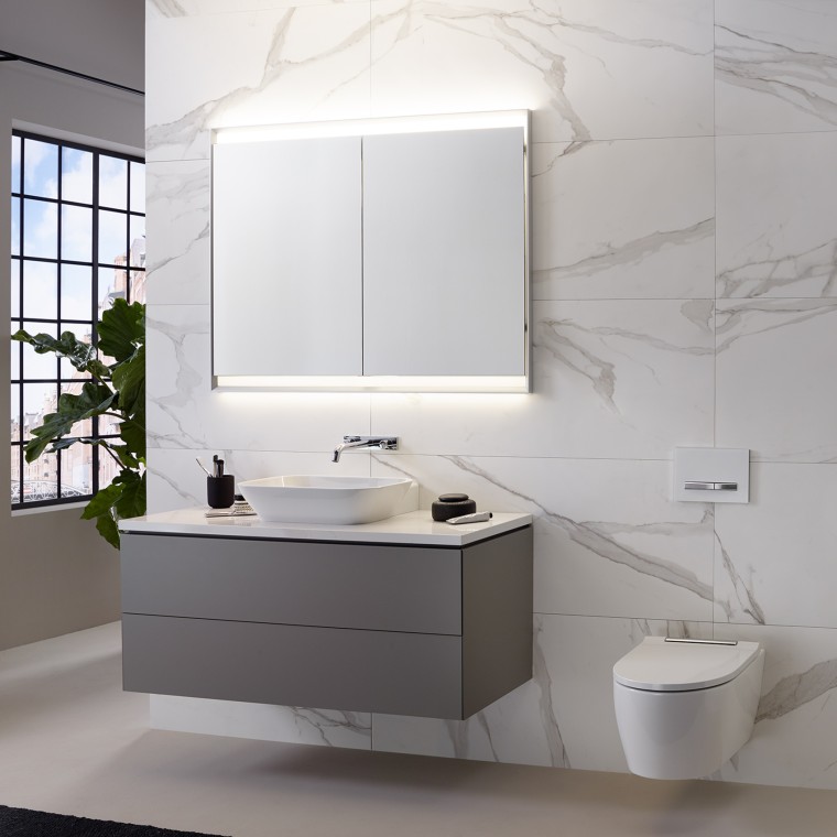Mur carrelé aspect marbre, lavabo et armoire de toilette avec ComfortLight et Geberit ONE