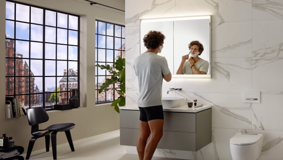 Homme se rasant au lavabo avec meuble et armoire de toilette Geberit ONE