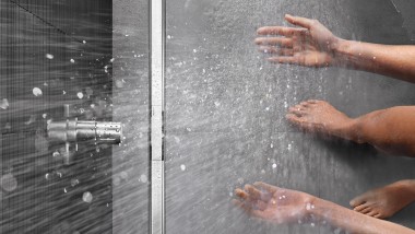 Personne se douchant dans une douche de plain pied Geberit CleanLine (© Geberit)
