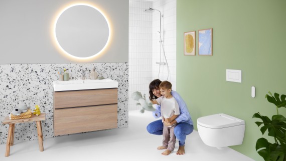 Geberit AquaClean Alba avec femme et enfant dans la salle de bains Geberit AquaClean Alba avec femme et enfant dans la salle de bains