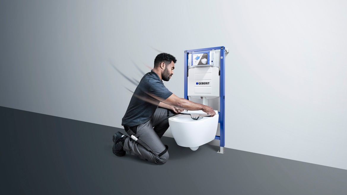 Installateur en train de poser un WC lavant Geberit AquaClean Installateur en train de poser un WC lavant Geberit AquaClean
