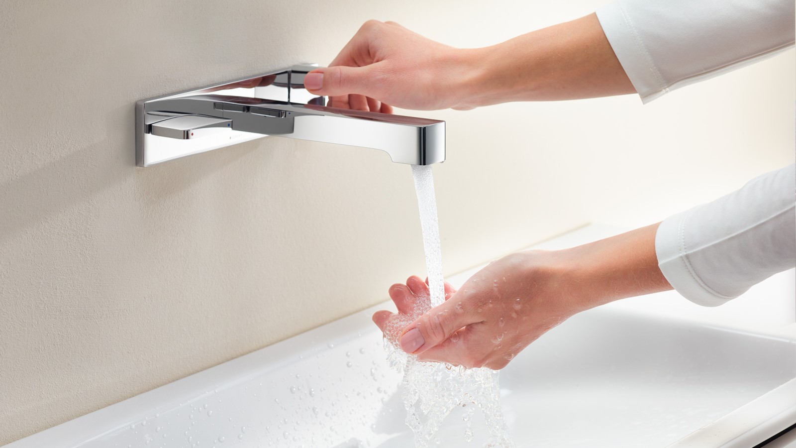 Une femme ouvre le robinet et teste lʼintensité et la température du jet dʼeau (© Geberit) Une femme ouvre le robinet et teste lʼintensité et la température du jet dʼeau (© Geberit)