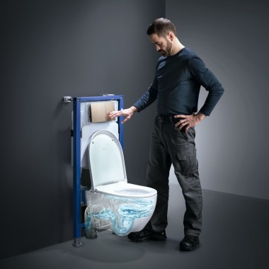 Un homme actionne la technologie de rinçage TurboFlush d'un WC Geberit Acanto