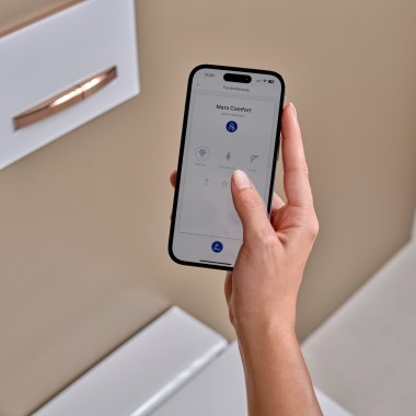 Une femme utilise l'application Geberit Home sur un smartphone Une femme utilise l'application Geberit Home sur un smartphone