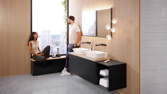 Une femme et un homme dans une grande salle de bains équipée d'un double lavabo Geberit ONE, d'un miroir Option et d'éléments en bois. Une femme et un homme dans une grande salle de bains équipée d'un double lavabo Geberit ONE, d'un miroir Option et d'éléments en bois.