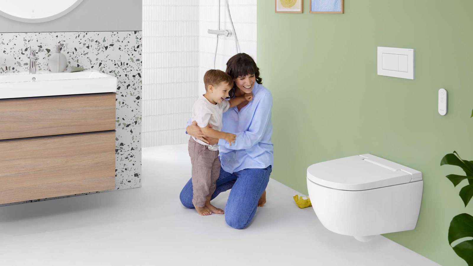 Femme avec enfant devant un WC lavant Geberit AquaClean Alba
