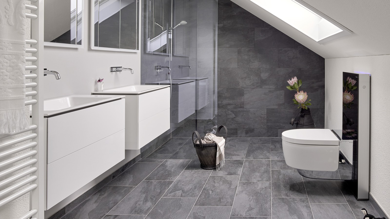 Salle de bains avec toit en pente et produits de la série Geberit ONE et Geberit AquaClean avec Monolith