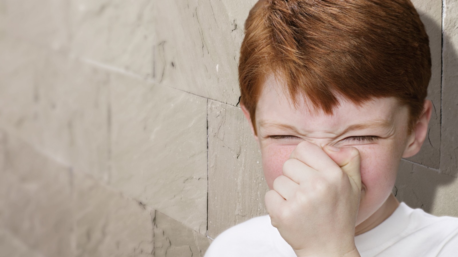 Un garçon qui se bouche le nez