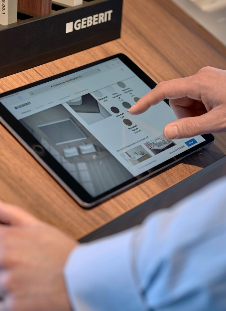 Un homme muni dʼune tablette choisit des produits dans un configurateur