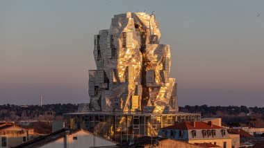 Les panneaux en aluminium dotés d’un revêtement spécial de la façade de la tour reflètent la lumière du soleil du soir, créant une atmosphère presque surnaturelle (© Adrian Deweerdt, Arles)