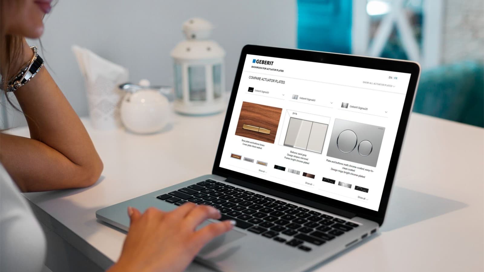 Une femme lance la salle d'exposition des plaques de déclenchement Geberit sur son ordinateur portable. Une femme lance la salle d'exposition des plaques de déclenchement Geberit sur son ordinateur portable.