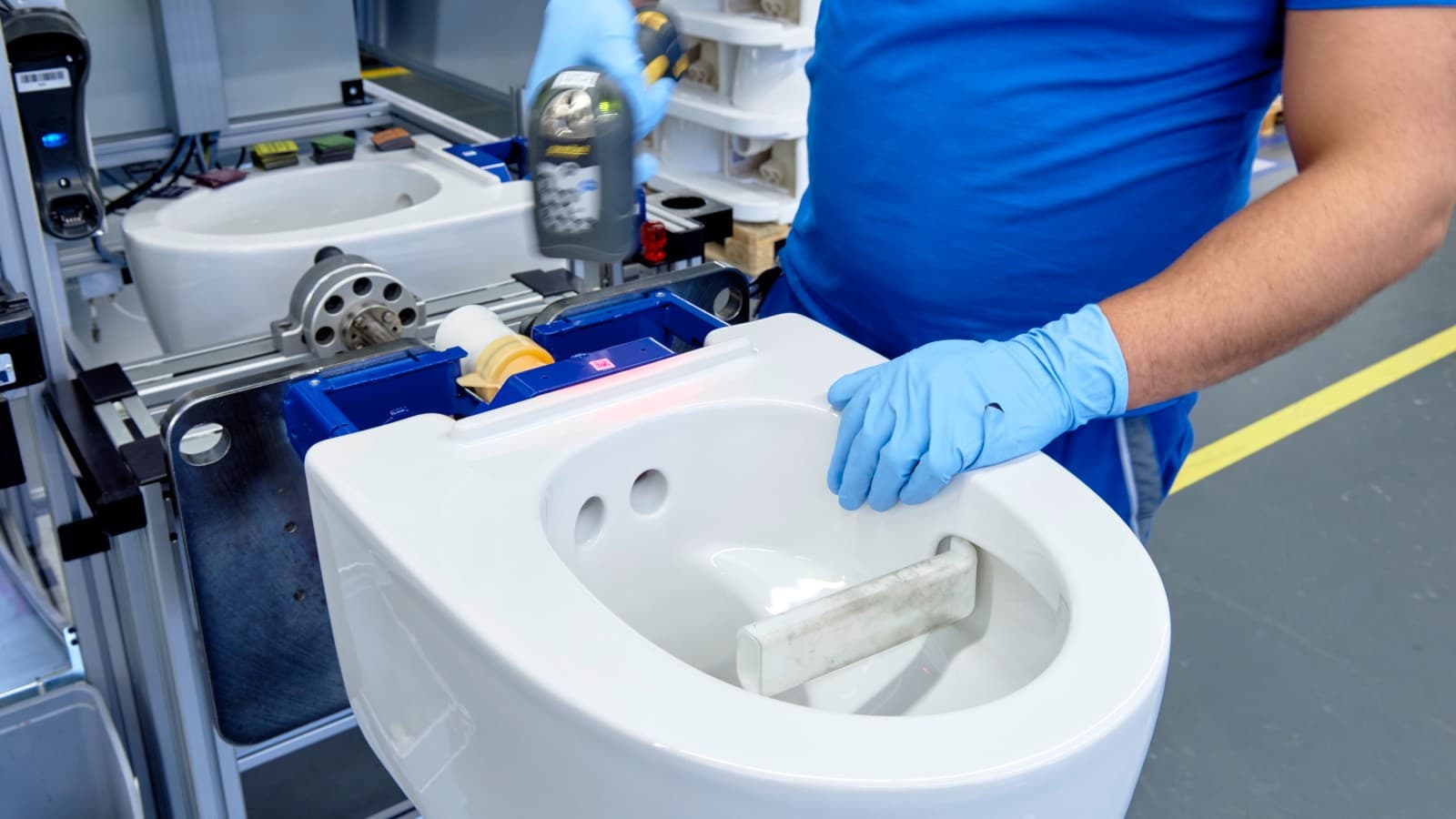 Un employé de Geberit travaille sur un WC lavant Geberit AquaClean Mera à Jona Un employé de Geberit travaille sur un WC lavant Geberit AquaClean Mera à Jona