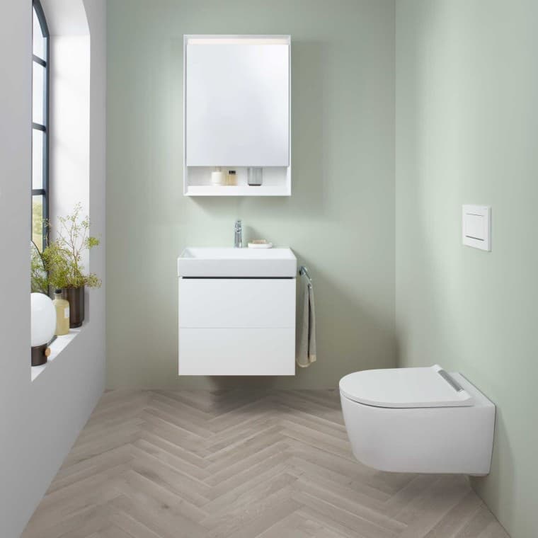 Zone lavabo Geberit ONE avec petit lavabo, meuble sous lavabo et armoire de toilette, ainsi qu'un WC lavant. Zone lavabo Geberit ONE avec petit lavabo, meuble sous lavabo et armoire de toilette, ainsi qu'un WC lavant.
