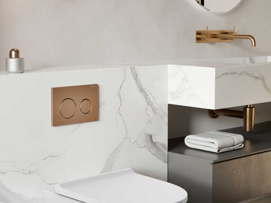 Salle de bains avec plaque de déclenchement Geberit en or rouge Salle de bains avec plaque de déclenchement Geberit en or rouge