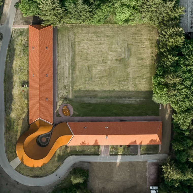 La vue plongeante montre le nouveau bâtiment rond qui relie les deux bâtiments historiques dotés d’une toiture en tuiles (© R_Hjortshoj) La vue plongeante montre le nouveau bâtiment rond qui relie les deux bâtiments historiques dotés d’une toiture en tuiles (© R_Hjortshoj)